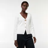 Cárdigan blanco de punto canalé con escote en V y cierre frontal con botones dorados.