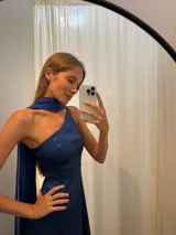 Vestido largo de fiesta color azul marino, con escote asimétrico de un solo hombro y un detalle de tela de gasa liviana que cae desde el hombro.