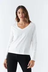 Remera blanca de algodón con escote en V y mangas largas.