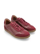 Zapatillas acordonadas doradas de cuero, con suela marrón de goma.
