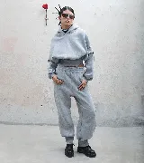 Buzo hoodie gris de tela deportiva con faja estilo corset y detalle de puño en manga.