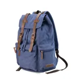 Mochila de tela canvas color verde oliva con tapa y detalles en símil cuero marrón. Cierre superior marinero, bolsillos internos, externos frontal, laterales y trasero con cierre. Asas rígidas, correas ajustables y espacio para laptop de 15".