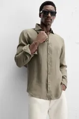 Camisa celeste de lino, de corte recto, manga larga y cuello clásico.