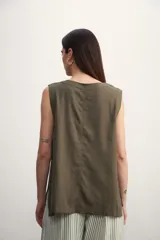 Blusa color crema sin mangas, de lino, con cuello redondo y corte recto.