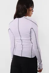 Top manga larga de morley color lila, con cuello redondo y detalle de costuras a contratono.