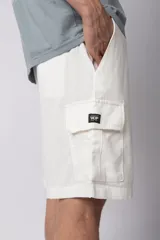 Bermuda cargo color blanco, confeccionada en mezcla de lino y rayón, con cintura elástica ajustable con cordón y bolsillo lateral tipo cargo.