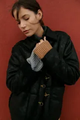 Campera marrón de cuero sintético con interior de corderito y cierre con alamares metálicos.