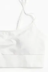 Bralette blanco de breteles finos regulables y bajo ancho acanalado. Copas forradas con relleno extraíble.