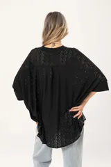 Camisa negra con calados, escote en V, abotonada y manga 3/4.