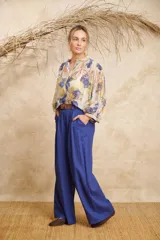 Pantalón ancho color beige de lino con cinto y pretina con elástico en la parte de atrás.
