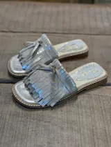 Sandalias plateadas con detalle de flecos y moño en la tira delantera.