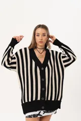 Saco oversize tejido a rayas verticales en blanco y negro, con escote en V y botones.