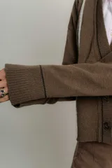 Saco de lana italiano azul con cuello en V, cierre con botones y ribetes en contraste.