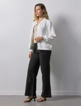 Campera bomber blanca con cuello a la base, abertura central con botones, bolsillos delanteros, ruedo y puños elastizados.
