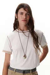 Remera blanca de manga corta con cuello redondo y detalle de costuras en contraste en cuello y mangas.