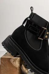 Botas de cuero color marrón oscuro, estilo Chelsea, con elástico lateral negro y suela track negra. Incluye correa de cuero desmontable con hebilla.