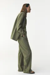 Pantalón de tiro alto color verde oliva, de corte recto y pierna ancha, con bolsillos laterales y traseros. Cierre frontal con cremallera y botón.