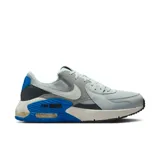 Championes Nike Air Max Excee de hombre, con capellada gris claro de mesh y cuero sintético, detalles en gris oscuro y azul, logo Nike blanco y suela blanca con cámara de aire visible.