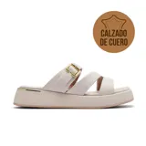 Sandalias bajas de cuero color beige, con plataforma y dos tiras anchas sobre el empeine. Una de las tiras tiene hebilla dorada ajustable.