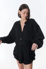 Camisa beige de manga larga con botones y detalles de encaje.