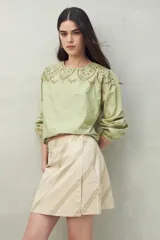 Minifalda color beige con rayas diagonales verdes.