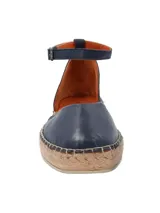 Alpargata femenina color marrón oscuro, con capellada de cuero y poliéster, forro de cuero y suela de TPR. Presenta punta redonda, plataforma de 3 cm y ajuste con hebilla en el tobillo.