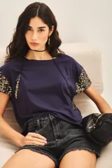 Remera azul marino de algodón con cuello redondo y mangas cortas con apliques de lentejuelas doradas.