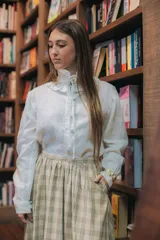 Camisa blanca de lino con cuello con volados y botones forrados.