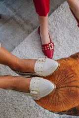Zapato de cuero rojo con taco cuadrado y detalle de hebilla dorada.