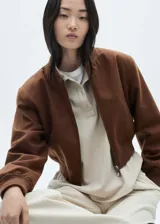 Chaqueta bomber marrón con cierre frontal, cuello redondo y puños elásticos.