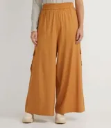 Pantalón pantalona color marrón, de lino y viscosa, con cintura elástica, bolsillos laterales y corte amplio.
