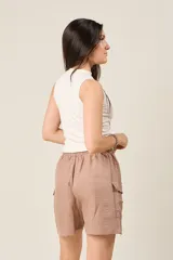 Short color marrón claro con cintura elástica ajustable con cordón, bolsillos laterales y bolsillos cargo con solapa en los muslos.