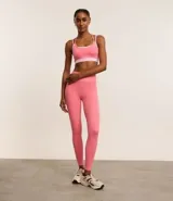 Top deportivo de microfibra color rosa con breteles finos y diseño de superposición bicolor.