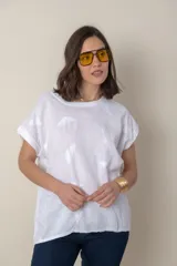 Blusa italiana color celeste con bordado de plumas al tono en el frente, confeccionada en lino y algodón.