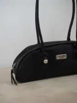 Cartera baguette con estampado animal print en tonos azul y marrón, con doble asa corta y cierre superior con cremallera.
