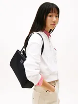 Cartera tote negra Tommy Jeans con doble asa corta, insignia con el logo de la marca en el frente y cierre superior con cremallera.