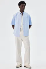 Camisa celeste de algodón Oxford con cuello abotonado, manga corta, bolsillo de parche en el pecho y corte regular.