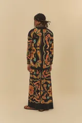 Pantalón de corte amplio con estampado de cachemir en tonos naranja, marrón y celeste sobre fondo negro. Presenta cintura elástica con cordón ajustable.