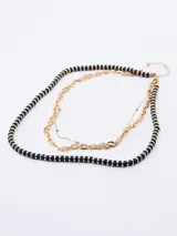 Collar dorado de tres hileras: una de cuentas azul marino con detalles dorados, otra de eslabones grandes y otra de eslabones pequeños.