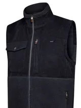 Chaleco beige con diseño de mitad sherpa y mitad cotelé, cuello alto y cierre frontal con cremallera. Incluye tres bolsillos con cremallera y un bolsillo con botón.