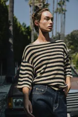 Top color beige de tejido de punto, con cuello redondo y mangas cortas tipo capa.