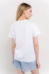 Remera blanca de algodón con estampado de un bolso con llavero colorido.