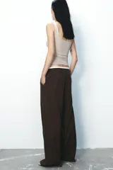 Pantalón ancho gris con textura de espiga, tiro alto, doble cintura elástica ajustable con cordón, pinzas frontales, bolsillos delanteros y falso bolsillo de vivo en la espalda.