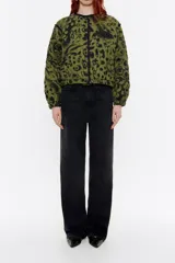 Cazadora corta acolchada de lino con estampado animal print en tonos verde oliva y negro. Tiene cuello redondo, cierre con botones a presión, mangas largas con volumen y puños fruncidos.