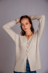 Blusa de morley elastizado color beige, de calce ajustado y mangas largas.