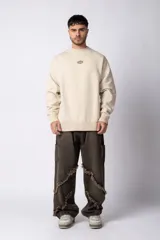 Buzo color beige de frisa con cuello redondo, mangas largas y logo bordado en el pecho.