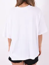 Remera blanca de corte holgado con estampa rectangular con una planta y un sol.