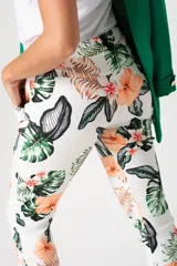 Pantalón babucha blanco con estampado de flores y hojas en tonos naranja, marrón y verde.