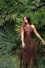 Vestido largo marrón con escote halter y flecos largos.