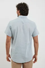 Camisa celeste de manga corta con cuello abotonado y bolsillo en el pecho.